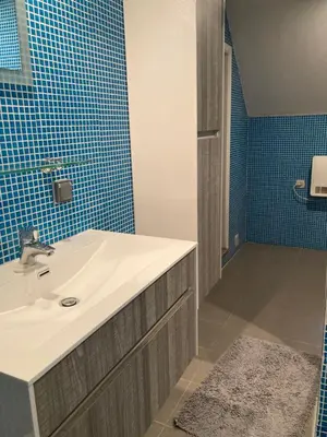 a bathroom with a sink and blue tiles at Gastroatelier in Gooik