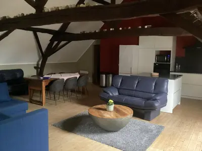 a living room with a blue couch and a table at Gastroatelier in Gooik