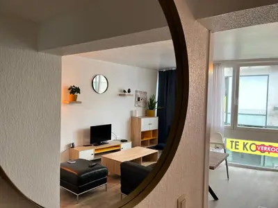 a living room with a table and a mirror at Vilvoorde city center in Vilvoorde