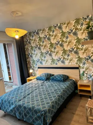 a bedroom with a bed with a blue comforter at Vilvoorde city center in Vilvoorde