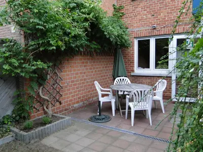 a patio with a table and chairs in front of a brick wall at Feel at home in Leuven in Leuven