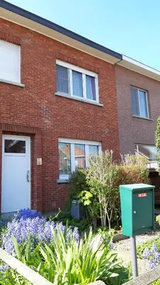 a brick house with a white door and some flowers at Feel at home in Leuven in Leuven