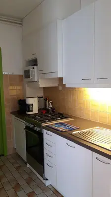 a kitchen with white cabinets and a stove top oven at Feel at home in Leuven in Leuven