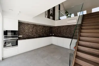 a kitchen with white cabinets and a staircase at Befour Vakantiewoning in Aalst