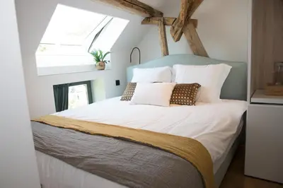 a bedroom with a large bed with white sheets and pillows at B&B Kraneveld in Haacht