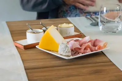 a plate of cheese and meats on a table at B&B Kraneveld in Haacht