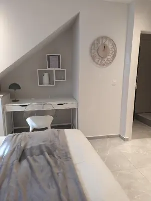 a bedroom with a desk and a bed with a chair at Archimède Suites in Brussels