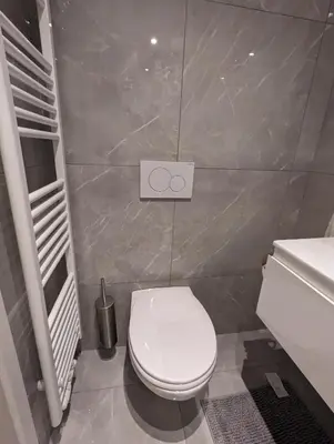 a bathroom with a white toilet and a sink at Archimède Suites in Brussels