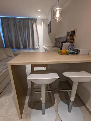 a kitchen with a wooden table and two stools at Archimède Suites in Brussels