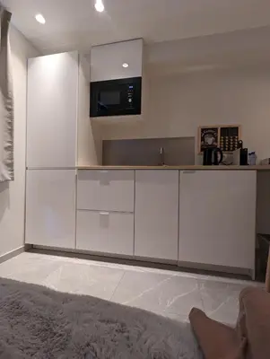 a kitchen with white cabinets and a microwave at Archimède Suites in Brussels