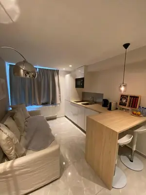 a kitchen and living room with a couch and a table at Archimède Suites in Brussels