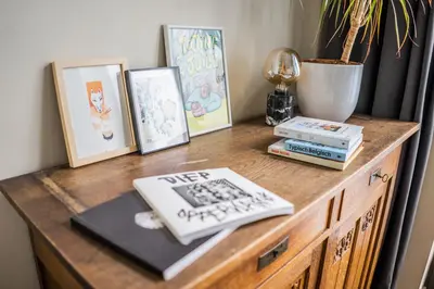 a wooden table with pictures and books on it at Casa Mina - Dok Noord Ghent in Ghent
