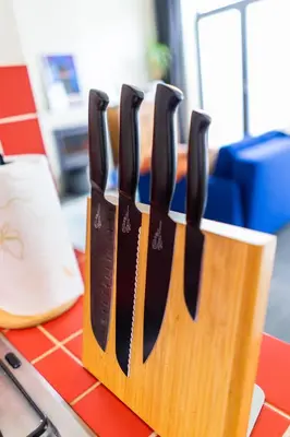 a group of knives in a wooden holder on a table at Casa Mina - Dok Noord Ghent in Ghent