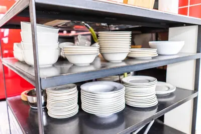 a shelf filled with white plates and bowls at Casa Mina - Dok Noord Ghent in Ghent