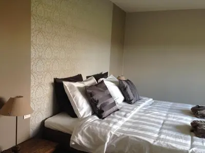a bed with black and white pillows in a bedroom at B&B Droomzoet in Herentals