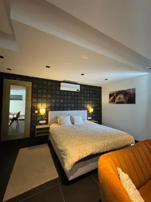 a bedroom with a large bed and a couch at Q Guesthouse in Herzele