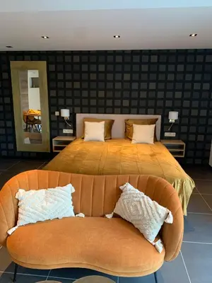a bedroom with a large bed and a couch at Q Guesthouse in Herzele