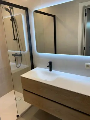 a bathroom with a sink and a shower with a mirror at Q Guesthouse in Herzele