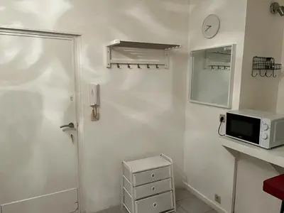 a white kitchen with a microwave and a sink at Appartements Brussels in Brussels