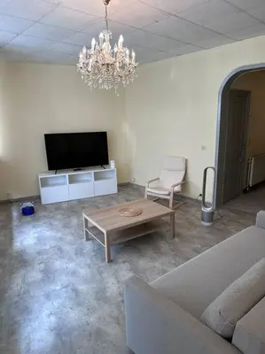 a living room with a couch and a table and a tv at Appartement à Bruxelles Midi - Grand place Bruxelles in Brussels