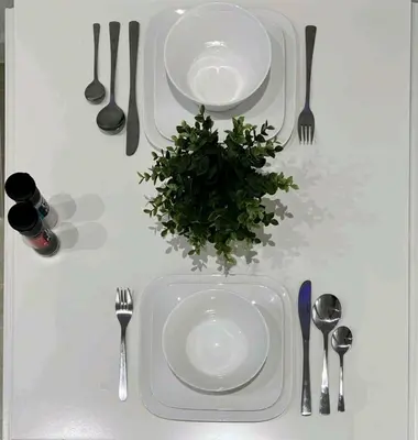 a table with plates and utensils and a plant on it at Sublime appartement Calme Cosy & Jacuzzi in Brussels