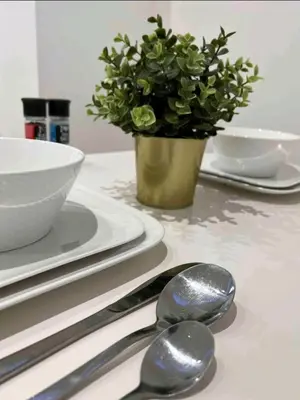 a table with silver spoons and a vase with a plant at Sublime appartement Calme Cosy & Jacuzzi in Brussels