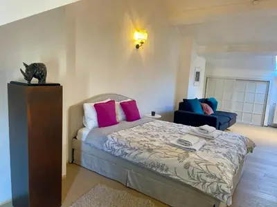 a bedroom with a bed with pink and blue pillows at The Doors City Park House in Ghent