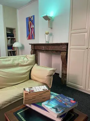 a living room with a couch and a table with books at The Doors City Park House in Ghent