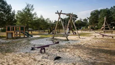 an empty playground with a bench in a park at Imagine Tiny House 325 op Camping GT te Balen in Balen