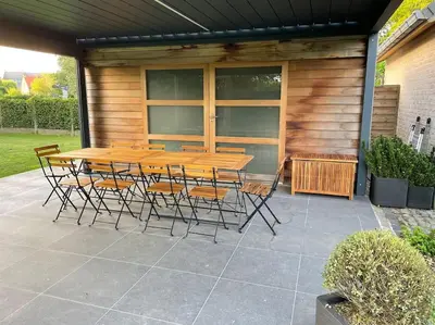 a wooden table and chairs on a patio at Wilgentuin in Bekkevoort