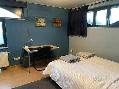 a bedroom with a bed and a desk with a chair at Wilgentuin in Bekkevoort