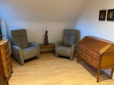 a room with two chairs and a dresser and a table at Wilgentuin in Bekkevoort