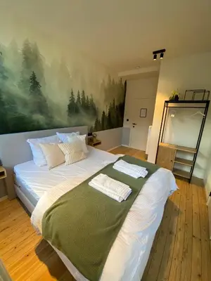 a bedroom with a large bed with a painting on the wall at Maison d’Arnaud in Ghent