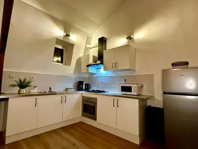 a kitchen with white cabinets and a white refrigerator at Luxury Suites Stay by Rikas Hotels in Antwerp