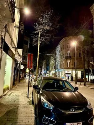 a car parked on the side of a street at night at Luxury Suites Stay by Rikas Hotels in Antwerp