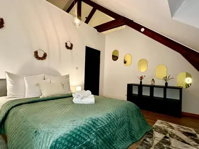 a bedroom with a green bed with mirrors on the wall at Luxury Suites Stay by Rikas Hotels in Antwerp