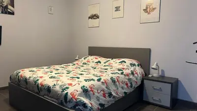 a bedroom with a bed with a floral comforter on it at Ruime studio in Deurne in Antwerp