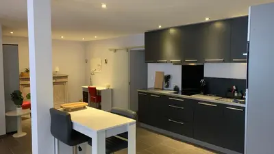 a kitchen with black cabinets and a white table at Ruime studio in Deurne in Antwerp