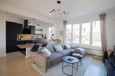 a living room with a couch and a kitchen at Plein centre de Waterloo! 2 in Waterloo