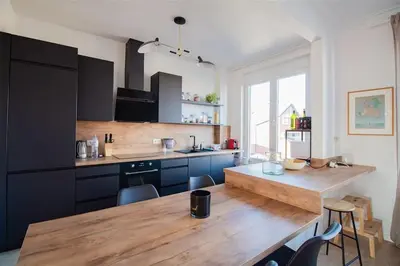 a kitchen with a wooden counter top and a table at Plein centre de Waterloo! 2 in Waterloo