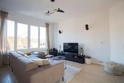a living room with a couch and a tv at Plein centre de Waterloo! 2 in Waterloo