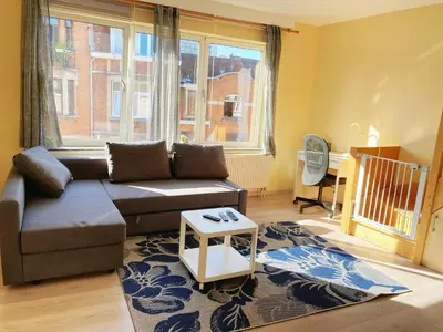 a living room with a couch and a table at Sweet home with big terrace in Brussels