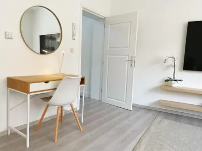 a white room with a desk and a mirror at Sweet home with big terrace in Brussels