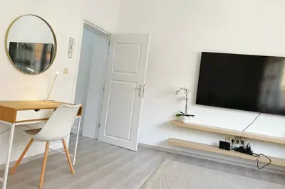 a room with a desk and a television on a wall at Sweet home with big terrace in Brussels