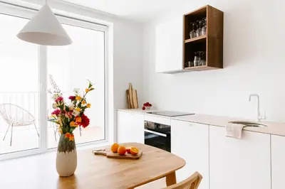 a kitchen with a wooden table with a vase of flowers at High-end flats at South area in Antwerp