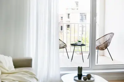 a living room with a window and a table and chairs at High-end flats at South area in Antwerp