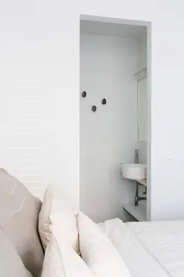 a white bedroom with a bed and a sink at High-end flats at South area in Antwerp
