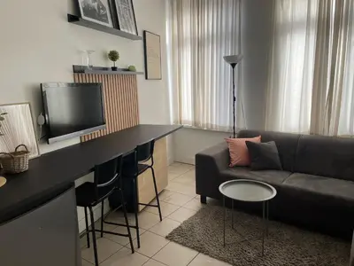 a living room with a couch and a table with a tv at Private studio in Antwerp in Antwerp