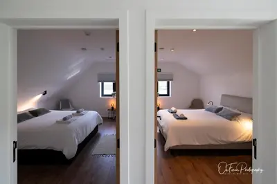 a bedroom with two beds and a hallway with a mirror at Vakantiehuis Paula in Watervliet
