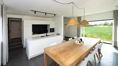 a kitchen and dining room with a wooden table at Vakantiehuis Paula in Watervliet
